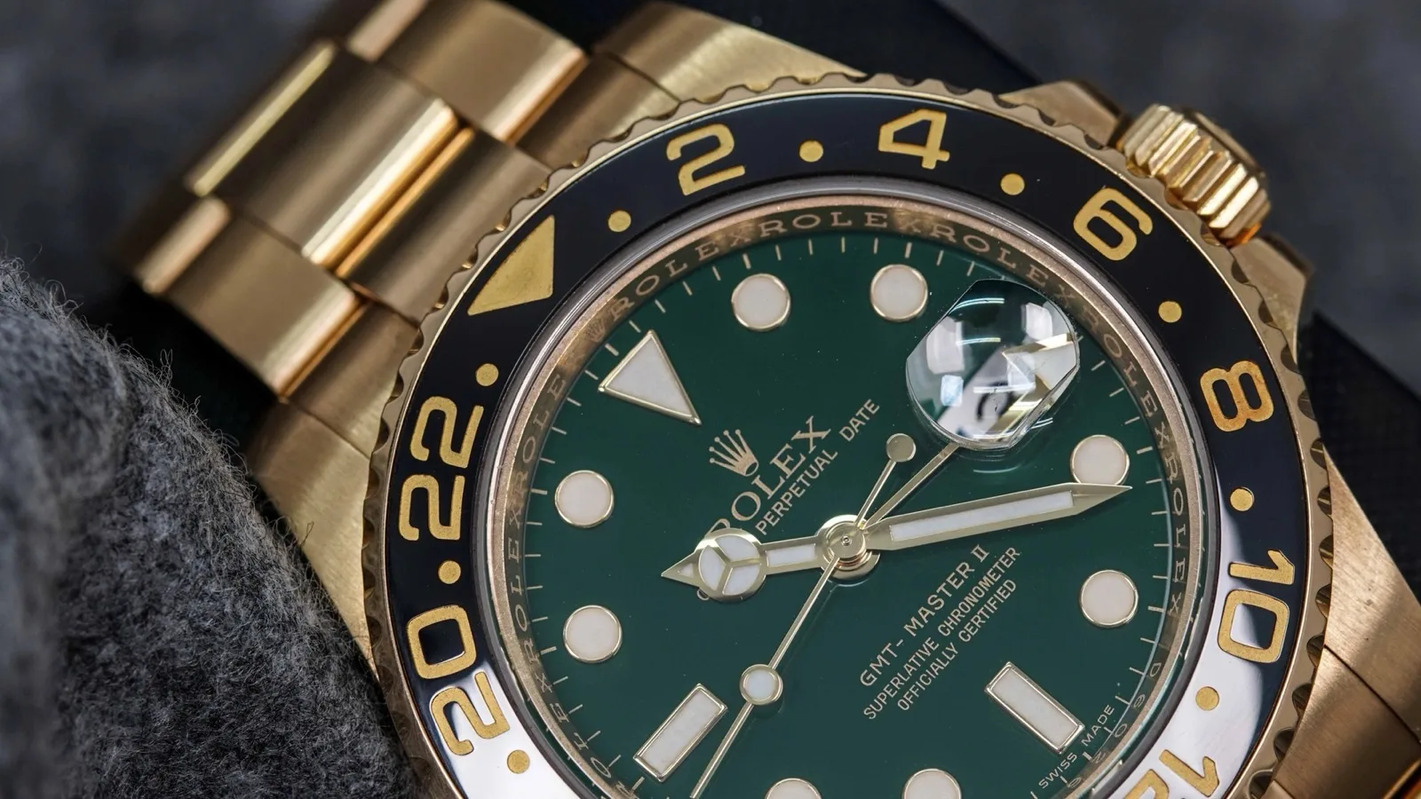 Cận cảnh Rolex GMT-Master II Ref. 116718LN vàng vàng, mặt xanh lá và vành 24 giờ đen