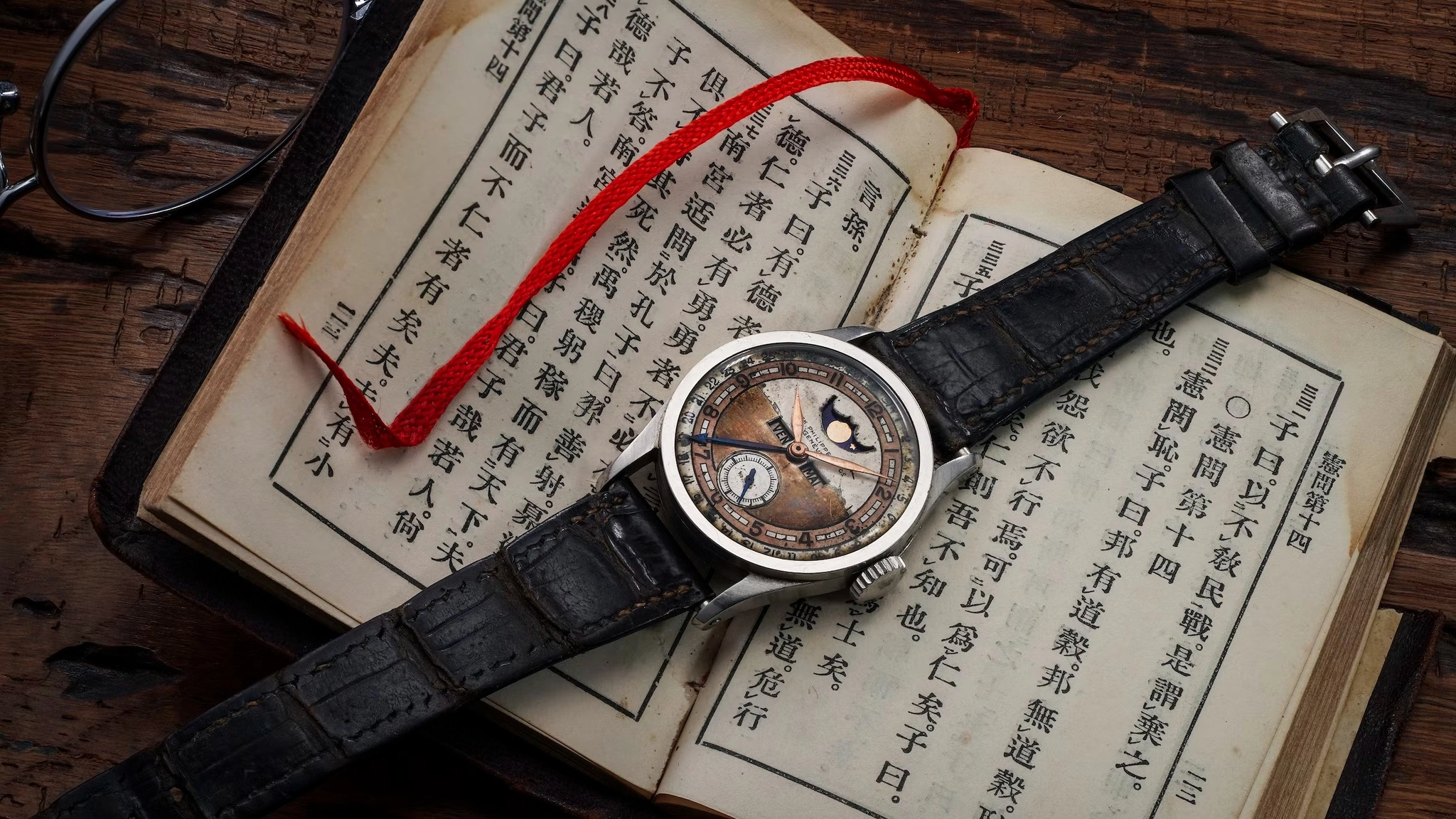 Patek Philippe Calatrava 96 lịch tuần trăng đặt trên cuốn sách cũ