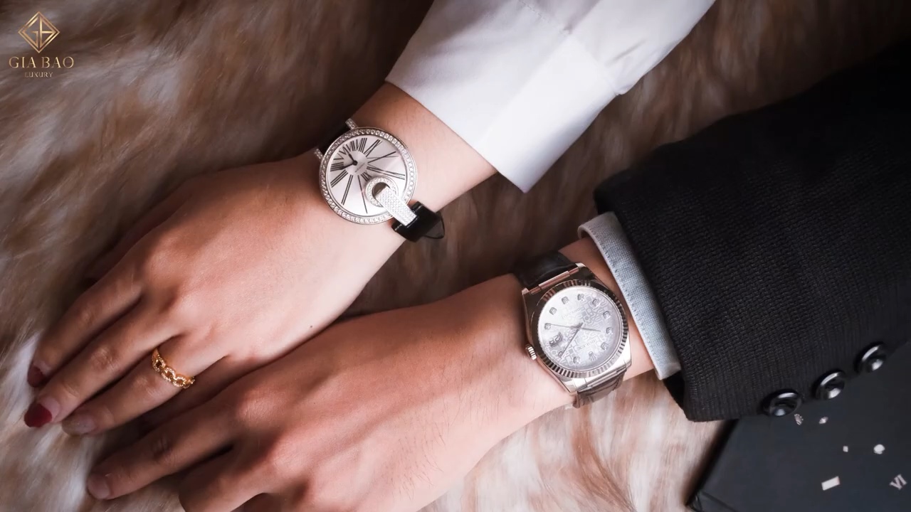 Cartier Captive de Cartier ở cổ tay phía trên và một chiếc Rolex ở cổ tay phía dưới