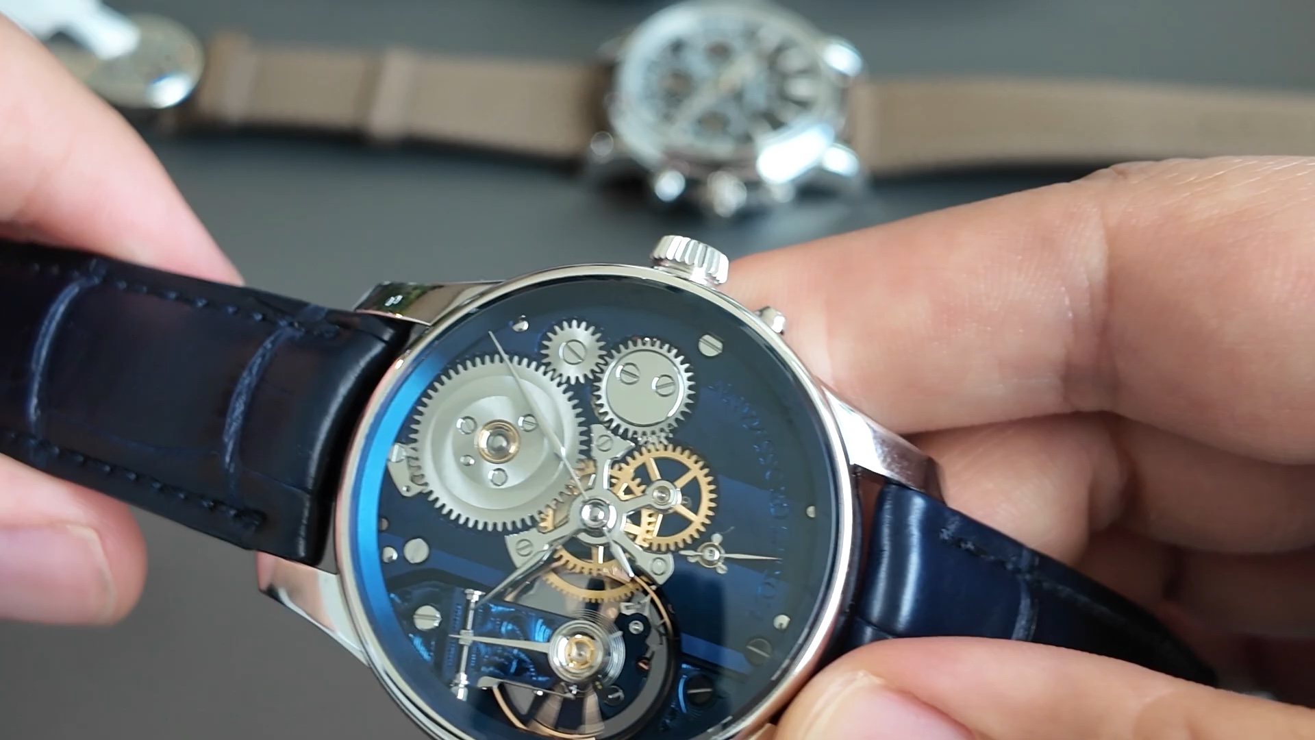 Mặt số xanh bán lộ cơ Moritz Grossmann Backpage Blue với bộ dao động và bánh xe cóc lộ ra mặt trước