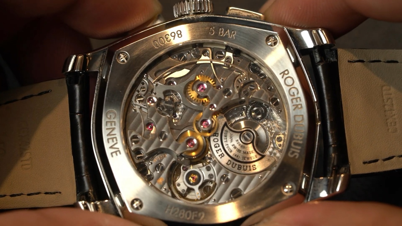 Mặt đáy sapphire của Roger Dubuis La Monégasque DBMG0005 với bộ máy và rotor trong video Gia Bảo