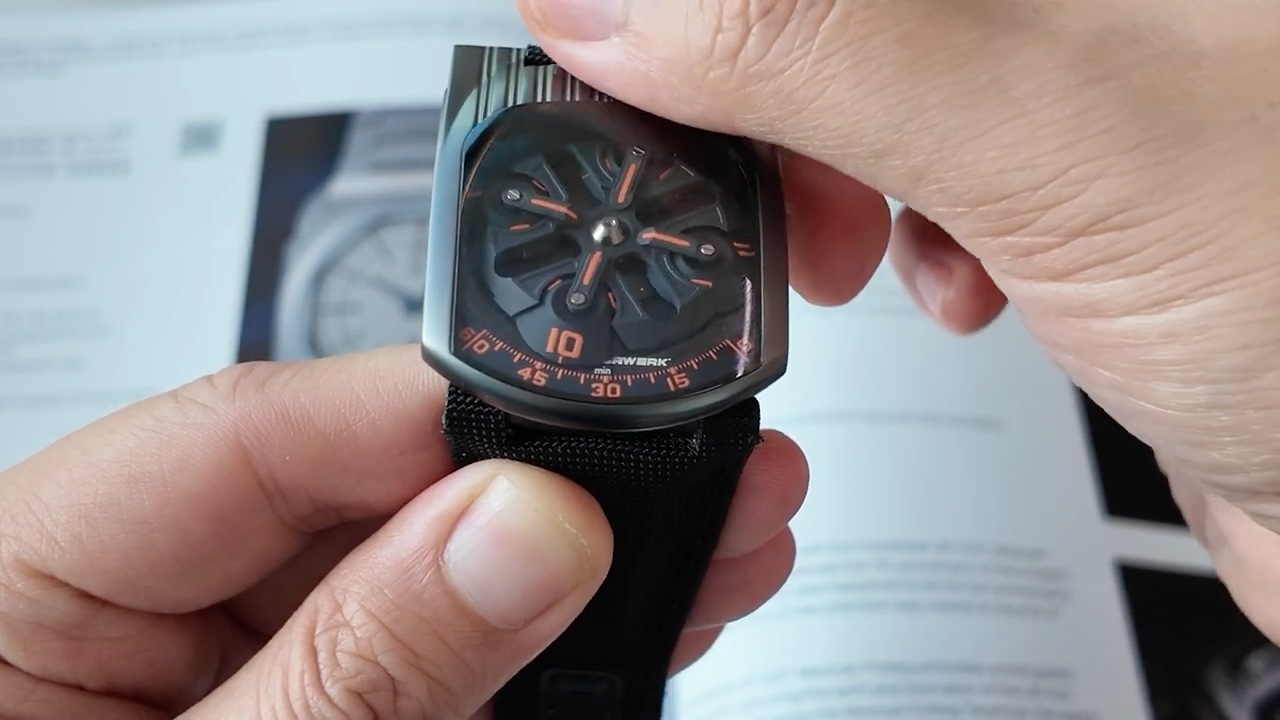 Urwerk UR-103T cầm trên tay với vệ tinh giờ màu cam