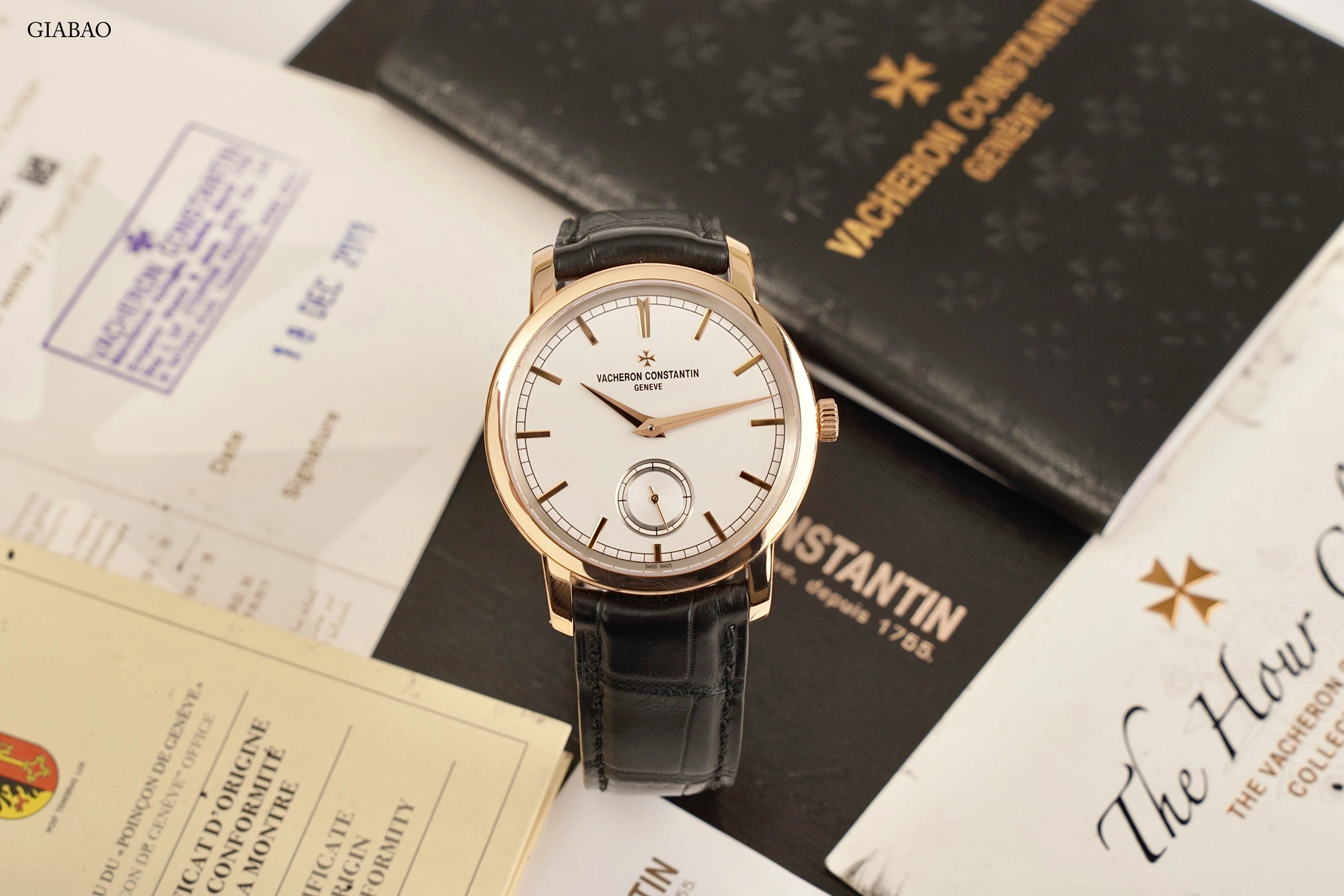 Toàn cảnh Vacheron Constantin Traditionnelle 82172 vỏ vàng hồng, mặt số bạc và dây alligator trên giấy tờ đi kèm