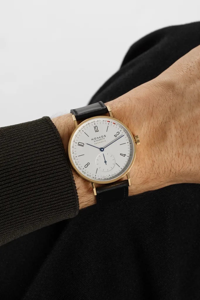 NOMOS Tangente gold neomatik 38 Update trên cổ tay với trang phục đen