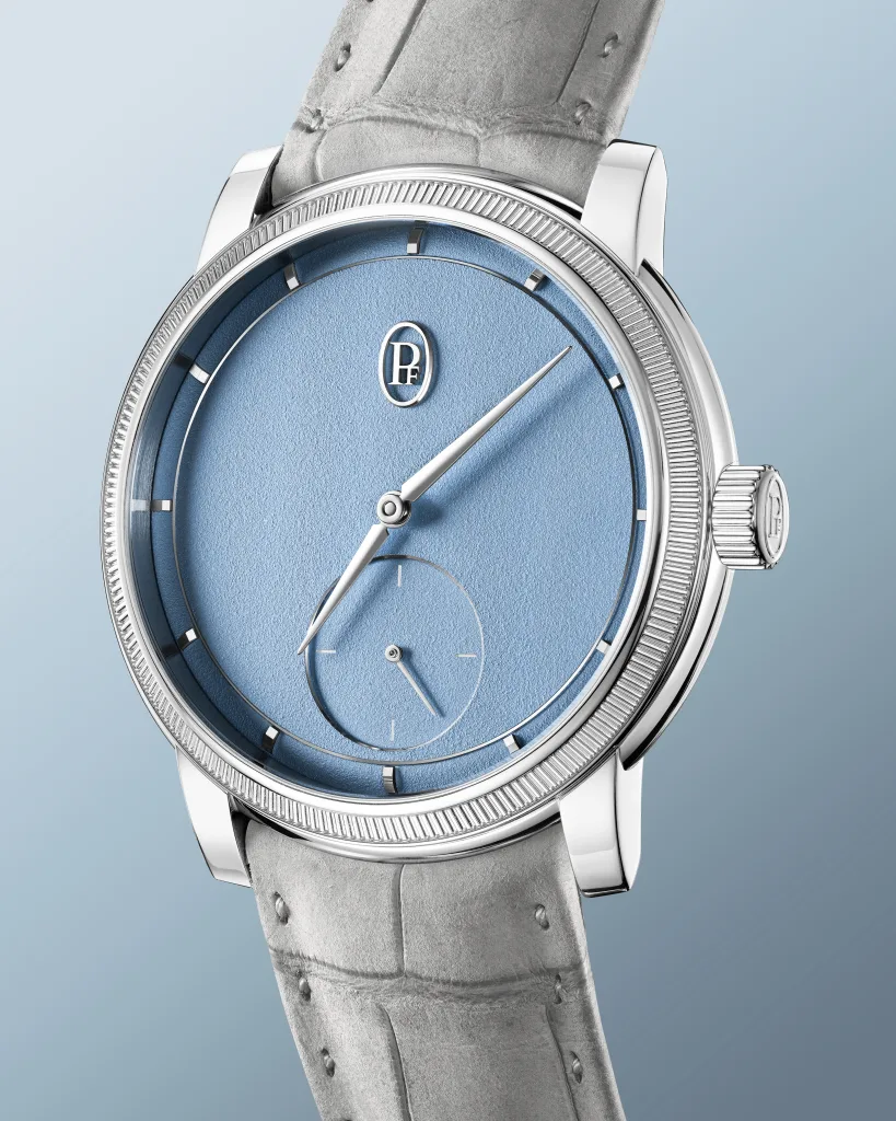 Cận cảnh mặt số Morning Blue tạo hạt, kim alpha và vành bezel khía của Toric Petite Seconde