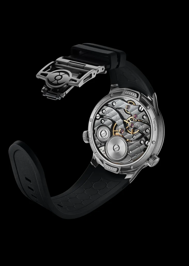 Mặt sau LM1 EVO titanium để lộ cầu máy sẫm màu, bánh răng và khóa gập mở